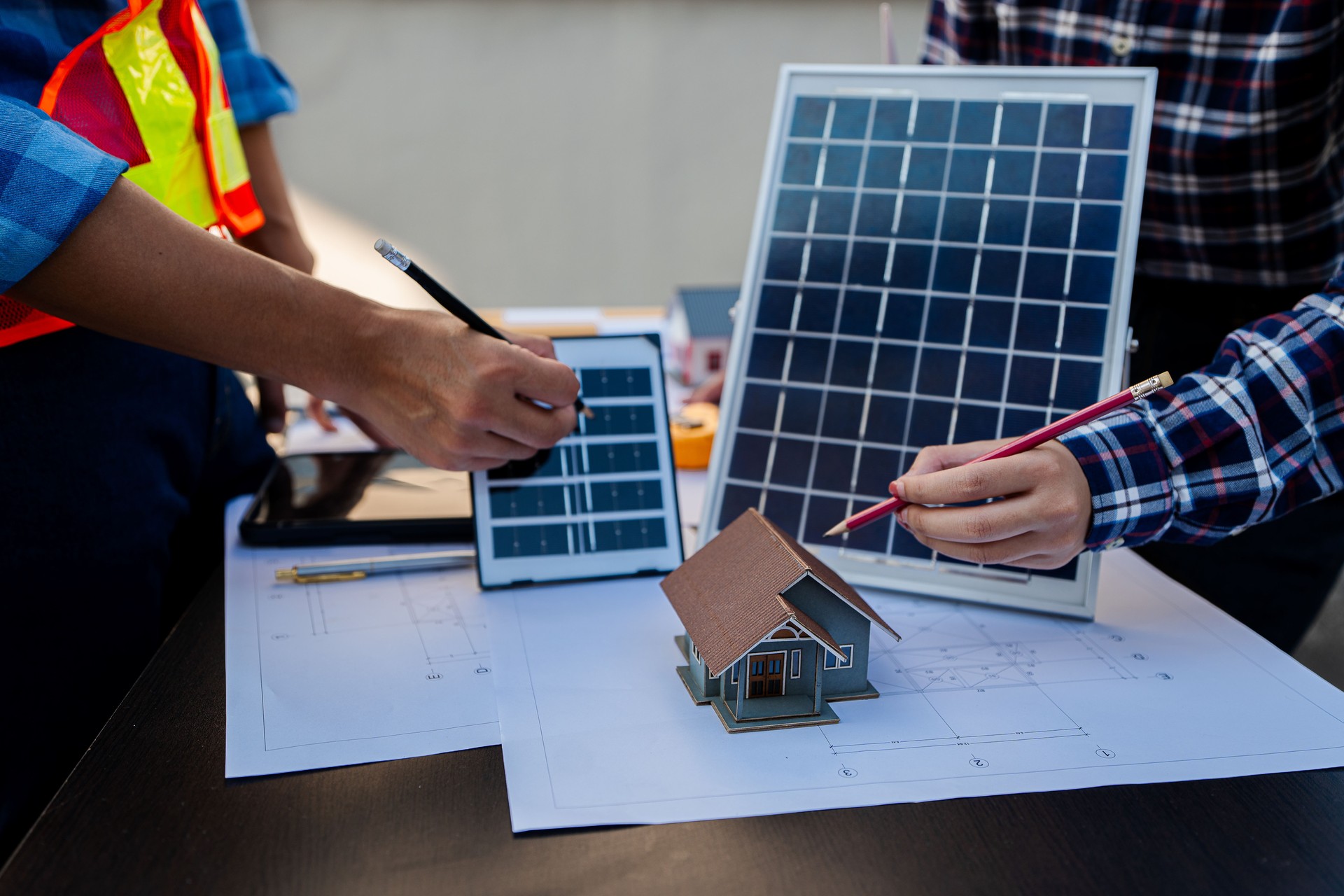Deux jeunes ingénieurs, experts en installation de cellules solaires, se rencontrent et discutent dans le bâtiment de l’usine, planifiant l’installation de panneaux solaires sur le toit.