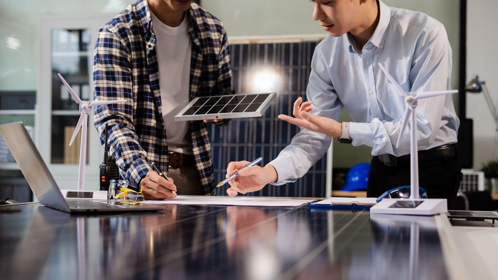 Équipe d’ingénieurs travaillant avec des plans pour l’esquisse d’un projet de construction, d’énergie verte et de concept de panneaux solaires.